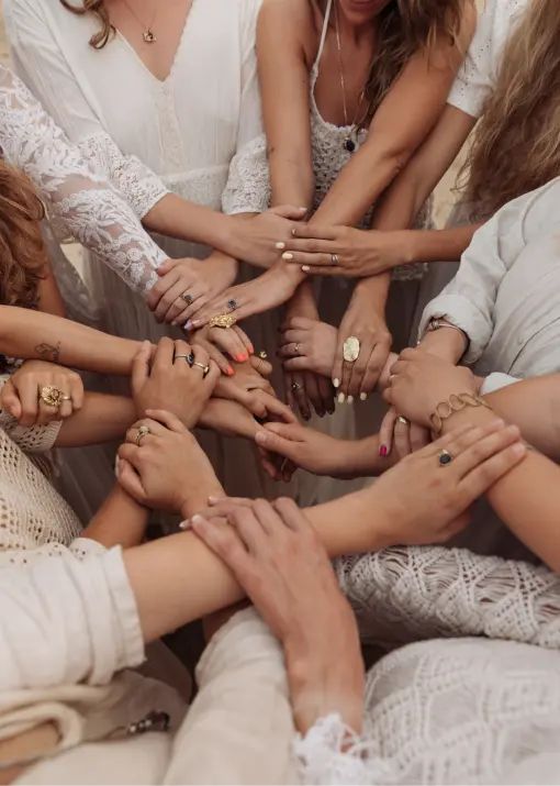 Mulheres reunidas com as mãos unidas em um círculo de acolhimento